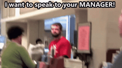 Man In Red Shirt Talking To Woman In Green Sweater Saying I Want To Speak To Your Manager GIF