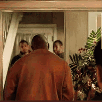 Man In Red Shirt Walking Through Doorway With Group GIF