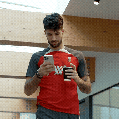 Man In Red Shirt With X Looking At Phone GIF