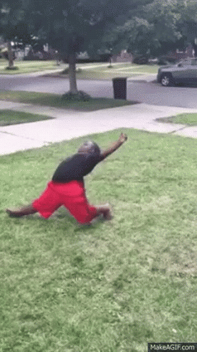 Man In Red Shorts Kneeling On Grass GIF
