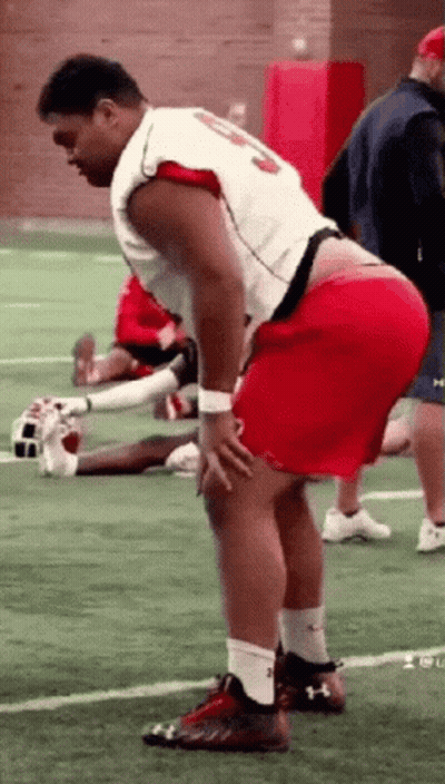 Man In Red Shorts Standing On Football Field Hands On Hips GIF
