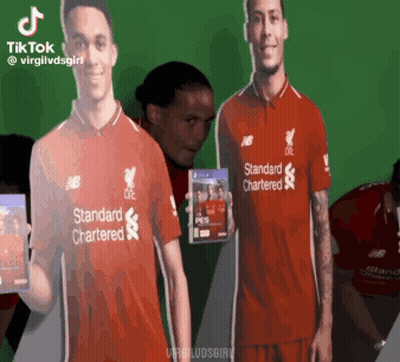 Man In Red Standard Chartered Shirt Holding Video Game GIF