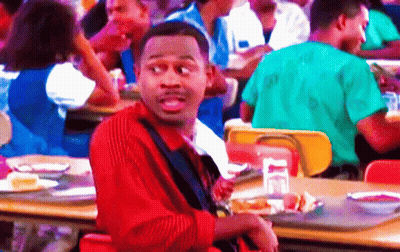 Man In Red Striped Shirt Sitting At Cafeteria Table GIF