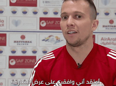 Man In Red Striped Shirt Talking In Front Of Airarab Sign GIF
