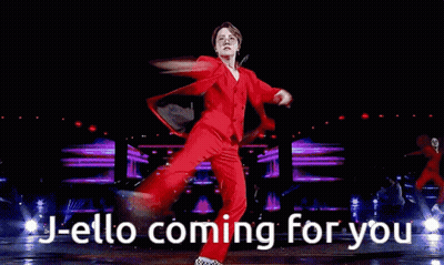 Man In Red Suit And Glasses Holding Microphone Says J-Ello Coming For You GIF