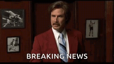 Man In Red Suit And Tie Holding Breaking News GIF