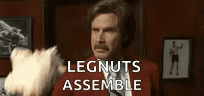 Man in Red Suit and Tie Holding Cotton Candy Saying Legnuts Assemble
