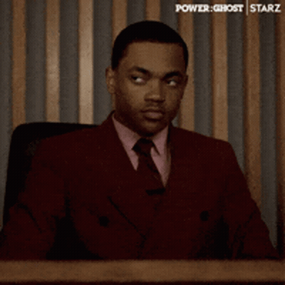 Man In Red Suit And Tie Sitting At Desk GIF
