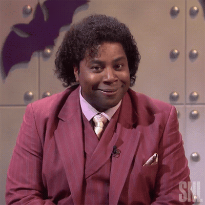 Man In Red Suit And Tie With SNL Letters GIF