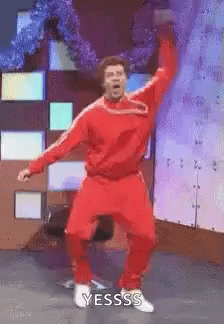 Man In Red Suit Dancing On Stage With Hands In Air GIF
