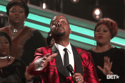 Man In Red Suit Singing Into Microphone In Front Of BET Logo GIF