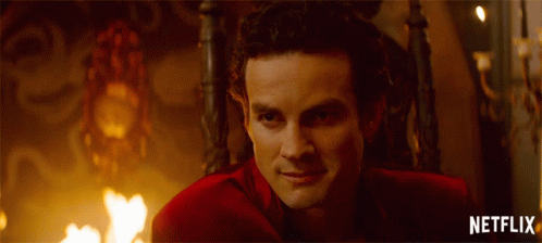 Man In Red Suit Sitting In Chair With Netflix Written Below GIF