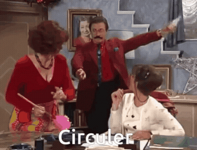 Man In Red Suit Standing Before Two Women Saying Circular GIF