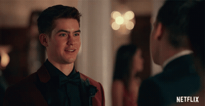 Man In Red Suit Talking To Man In Black Tuxedo GIF