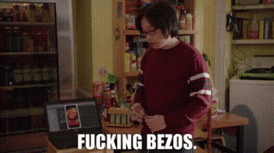 Man In Red Sweater At Table With Laptop And Refrigerator GIF