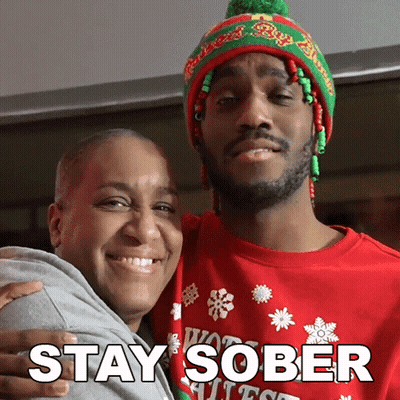 Man In Red Sweater Hugging Woman In Green And Red Hat GIF