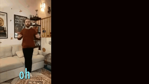 Man In Red Sweater Standing In Front Of Couch GIF