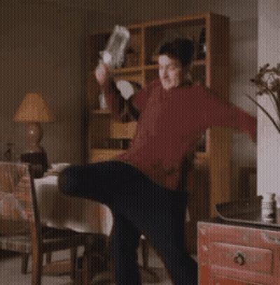 Man In Red Sweater Standing In Living Room GIF