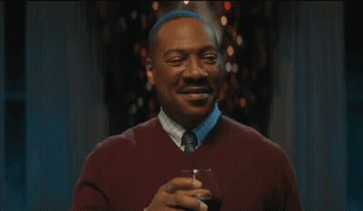 Man In Red Sweater Tie Smiling Holding Wine GIF