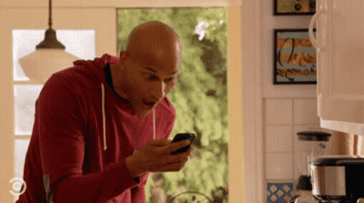 Man In Red Sweatshirt Looking At Cell Phone GIF