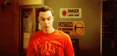 Man In Red T-Shirt In Front Of Danger Laser Sign GIF