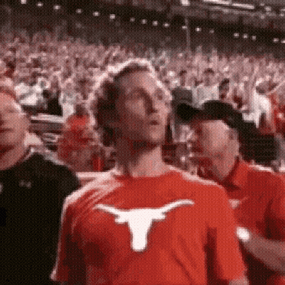 Man In Red T-Shirt With Longhorn In Crowd GIF