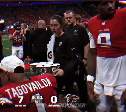 Man In Red Tagovailoa Jersey Holding Gatorade Can GIF