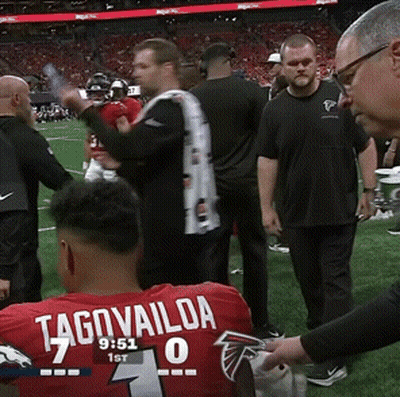 Man In Red Tagovailoa Jersey Sitting On Football Field GIF