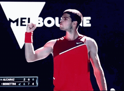 Man In Red Tank Top Standing At Melbourne Sign GIF