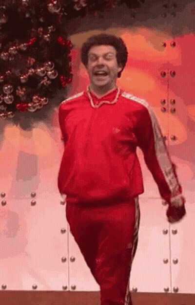 Man In Red Tracksuit Walking By Christmas Tree GIF