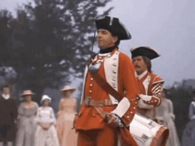 Man In Red Uniform Holding Drum In Front Of Crowd GIF
