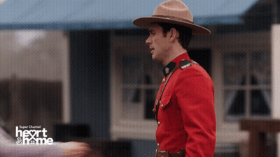 Man In Red Uniform In Front Of Heart & Name Building GIF