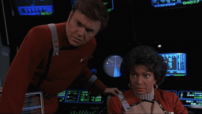 Man In Red Uniform Next To Woman At Computer Screen Saying 040.7 GIF