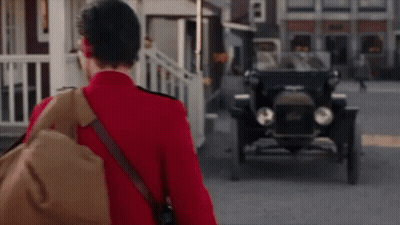 Man In Red Uniform Walking Toward Old Car GIF