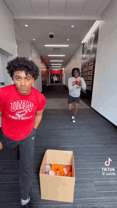 Man In Red Univ Football Shirt Next To Beer Cups Box GIF