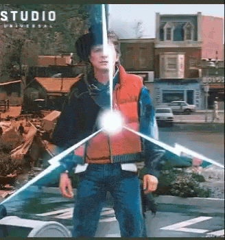 Man In Red Vest In Front Of Studio Universal Building GIF