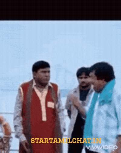 Man In Red Vest Talking To Man In Blue Scarf GIF
