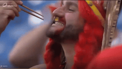 Man In Red Wig Eating With Chopsticks On Ouvio Screen GIF