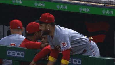 Man In Reds Jersey Hugging Another In Dugout GIF