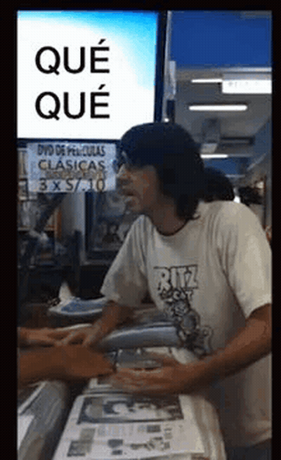 Man In Ritz Shirt In Front Of DVD De Peliculas Clasicas Sign GIF