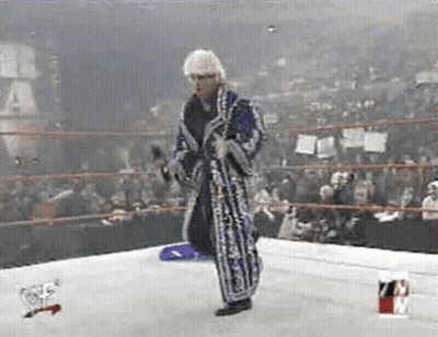 Man In Robe Holding Microphone In Wrestling Ring GIF