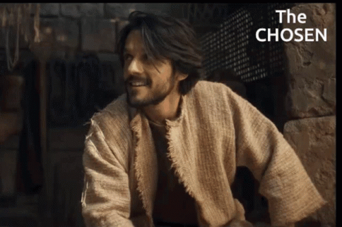 Man In Robe Smiling In Front Of The Chosen Sign GIF