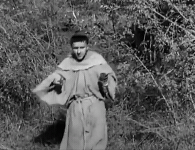 Man In Robe Standing In Field With Trees GIF
