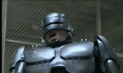 Man In Robot Suit Standing At Fence Mouth Open GIF