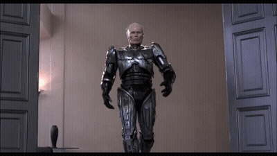 Man In Robot Suit Standing In Room GIF