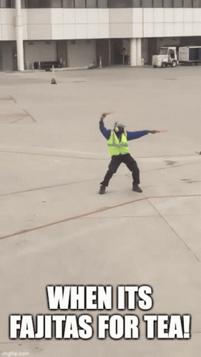 Man In Safety Vest Jumping With Sign Saying When It's Fajitas For Tea GIF