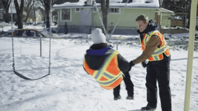Man In Safety Vest Pushing Child On Swing GIF