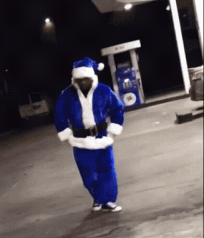 Man In Santa Costume Dancing In Front Of Gas Pump GIF