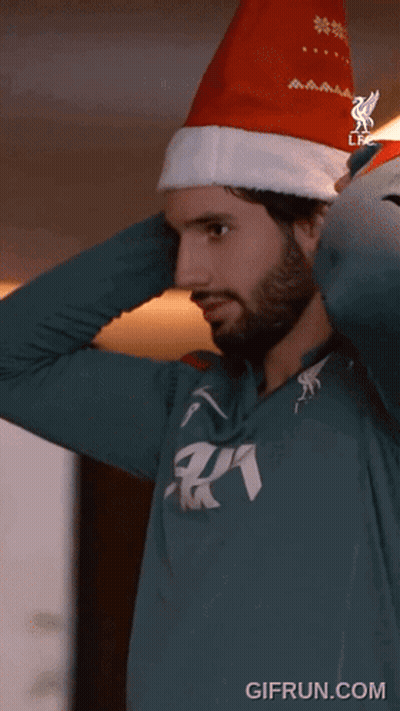 Man In Santa Hat And Green AA Shirt GIF
