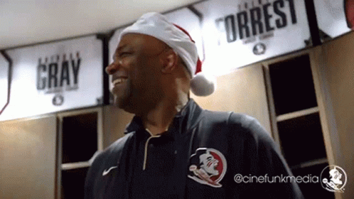 Man In Santa Hat In Front Of Sign Gray And Torrest GIF